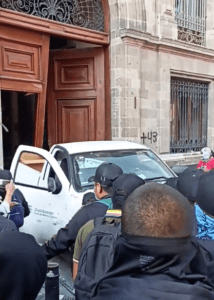 Normalistas de Ayotzinapa derriban puerta de Palacio Nacional con una camioneta