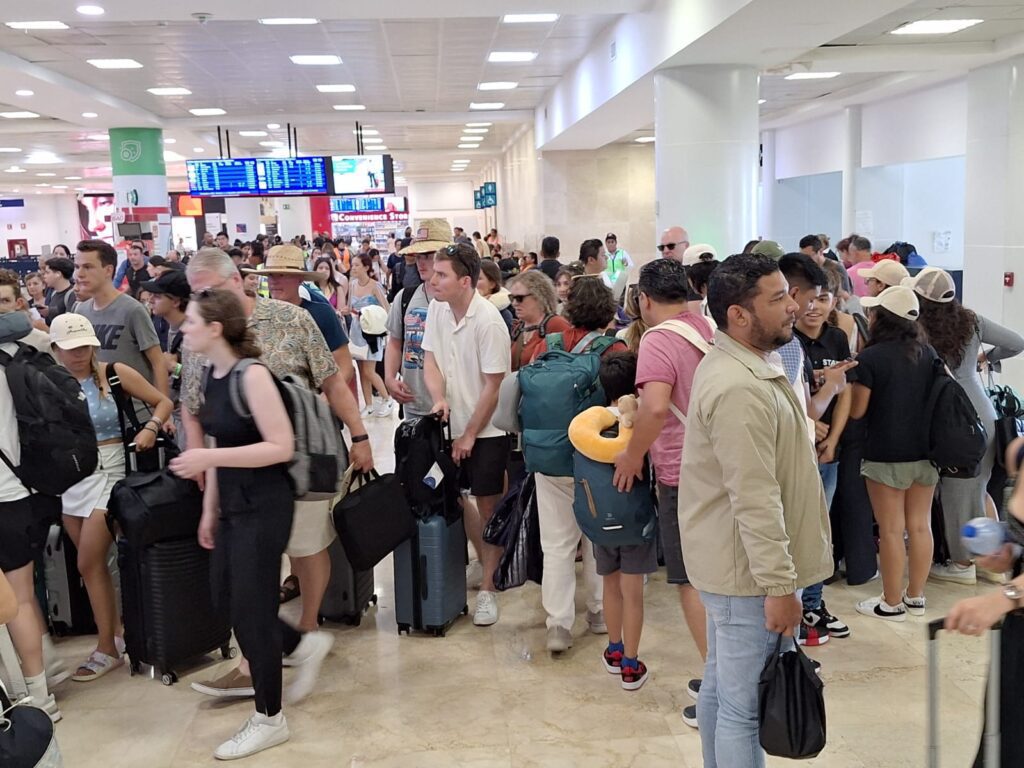 Largas filas en el Aeropuerto de Cancún por el huracán Beryl